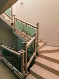 Escaleras interiores con barandales de cristal y estructura metálica en el edificio de tres niveles en Toluca.